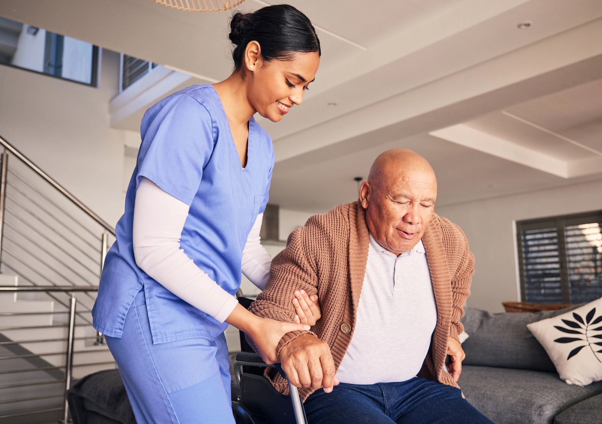 Caregiver assisting elderly man on staircase